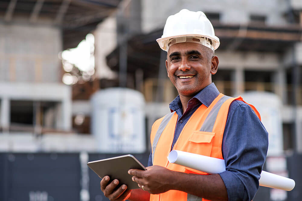 insights1 constructor worker with hard hat holding a tablet and smiling